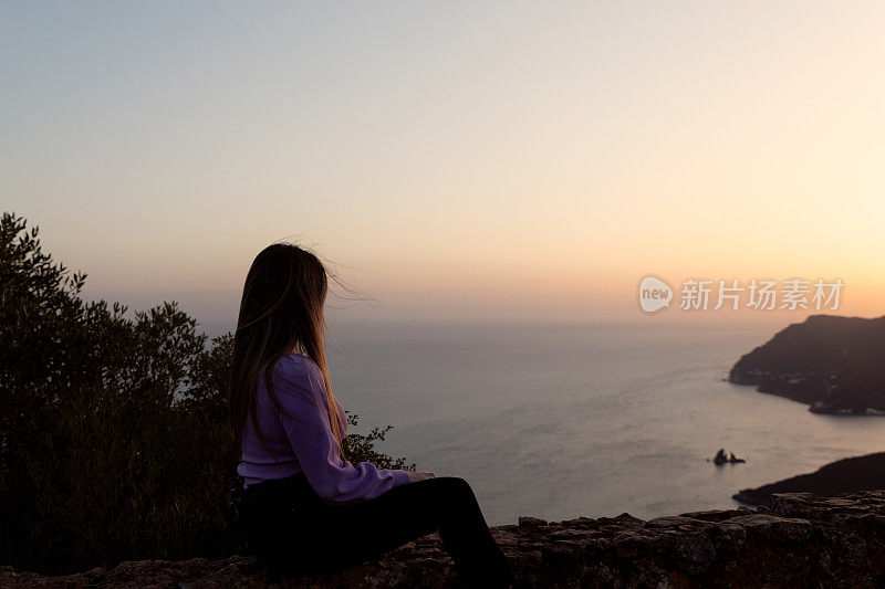 一位女士在Portinho da欣赏日落Arrábida